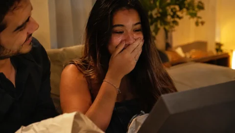 Namorada emocionada ao abrir o presente que ganhou do namorado