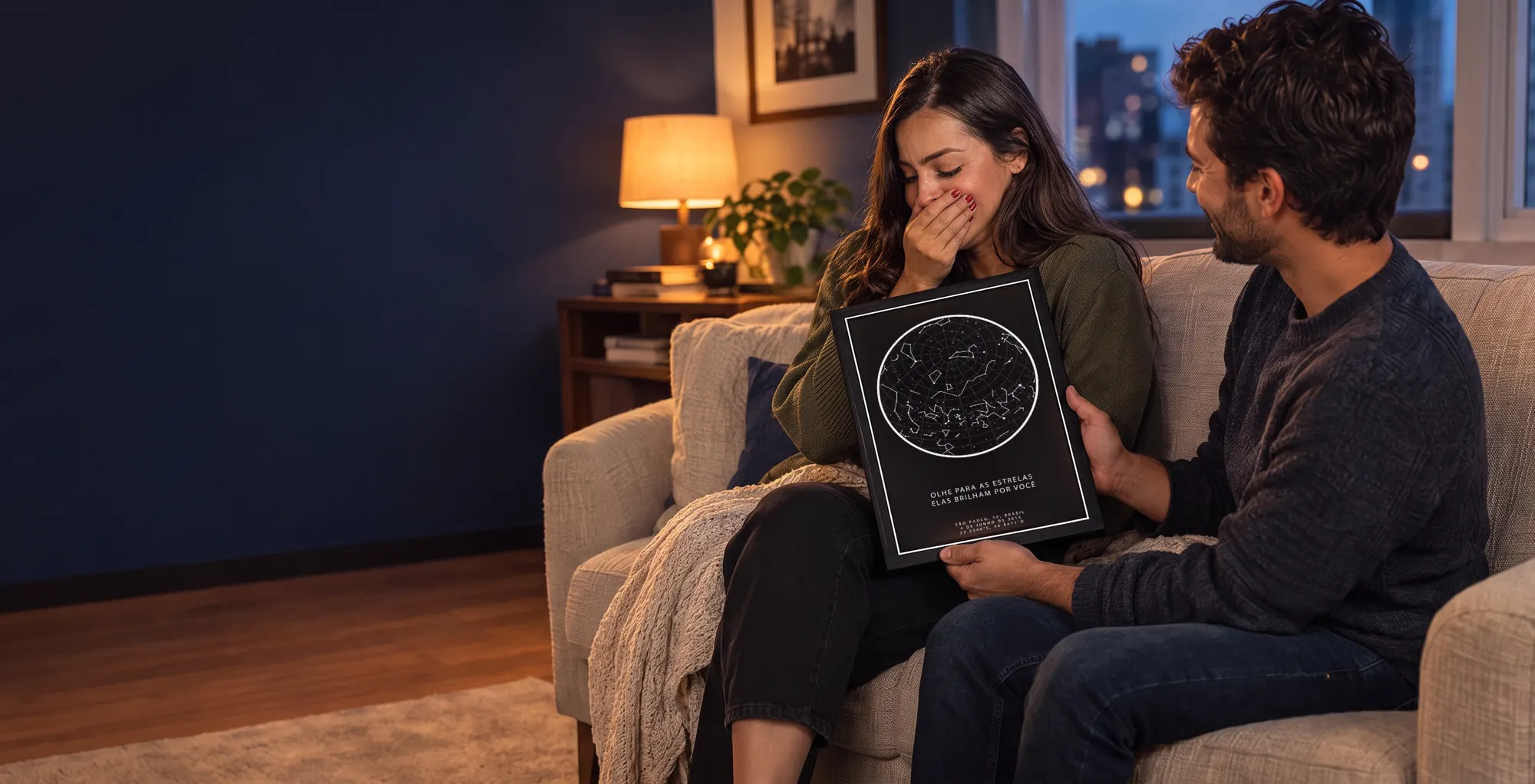 Casal emocionado no sofá com o quadro do mapa das estrelas de presente